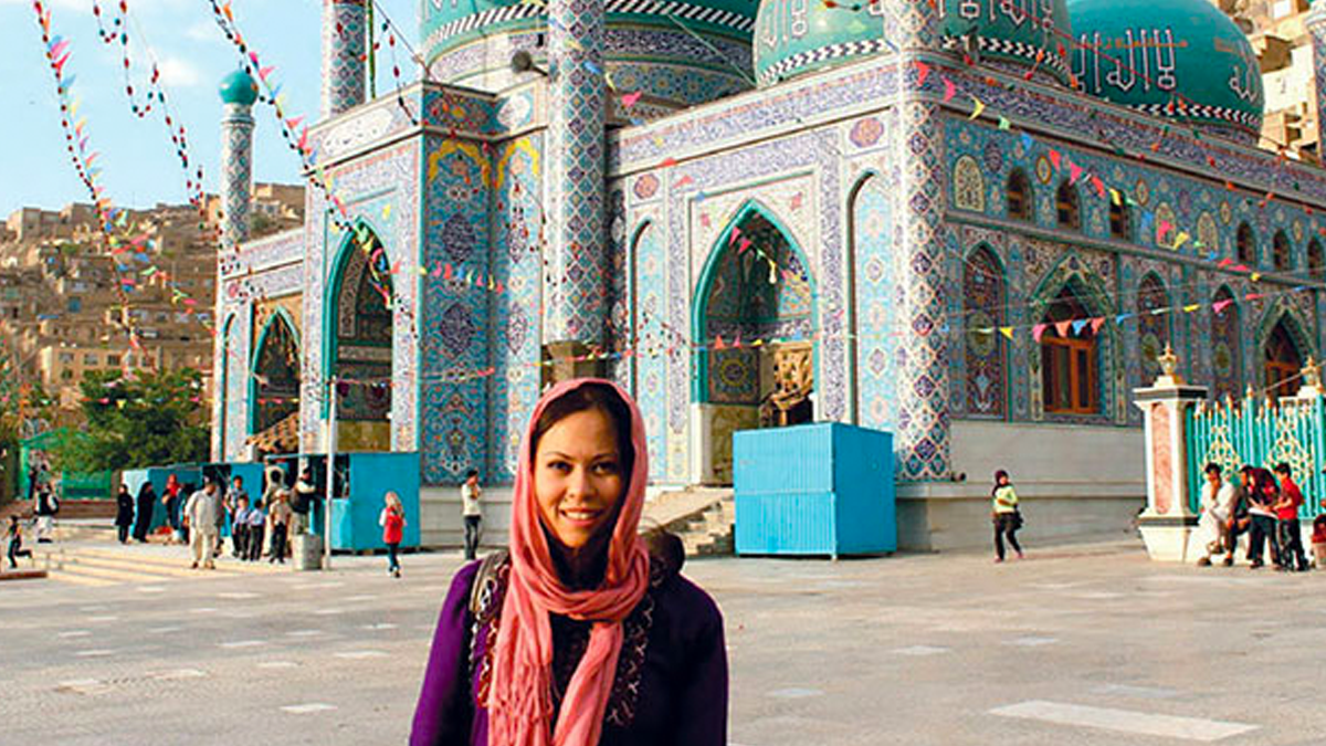 Woman standing in front of a mosque.